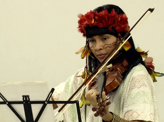 Adana Kambeba, aluna da Faculdade de Medicina da UFMG, toca violino na cerimônia de encerramento de seu ciclo didático no ICB. Foto: Foca Lisboa/UFMG